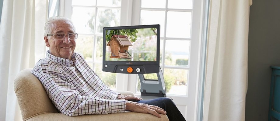 man sitting in chair looking at camera with Reveal 16 product next to chair